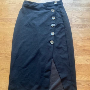 Svart tight kjol - Snygg svart tight kjol med slits som formar sig efter kroppen fint. Storlek xs.