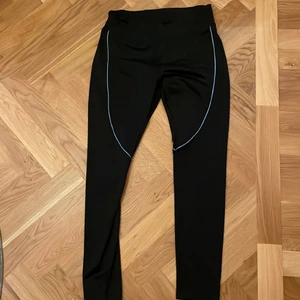 Svarta träningsbyxor 💪🖤 - Svarta tränings byxor som är helt oanvänd med blå sträck som detaljer 💙 Riktigt kapp!