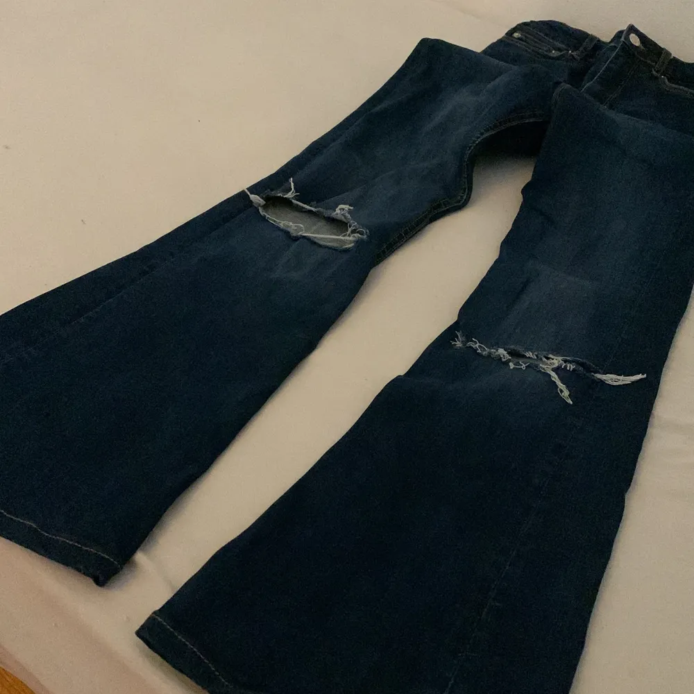 Snygga mörkblå Bootcut Jeans med hål på knäna. Strolek 34! Jeansen är från Zara och är uppsydda 3-4 cm💞Finns inga fläckar osv. Utgångspris 150kr, går att buda (:. Jeans & Byxor.