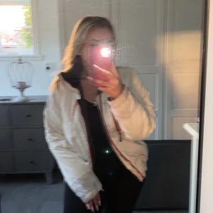 Skid/vinterjacka från Didriksons - Superfin vit/grå skid/vinterjacka med röda detaljer ifrån Didriksons, väldigt bra skick! Fler bilder kan fås. Strl 170 men passar mig som är 36/38. 