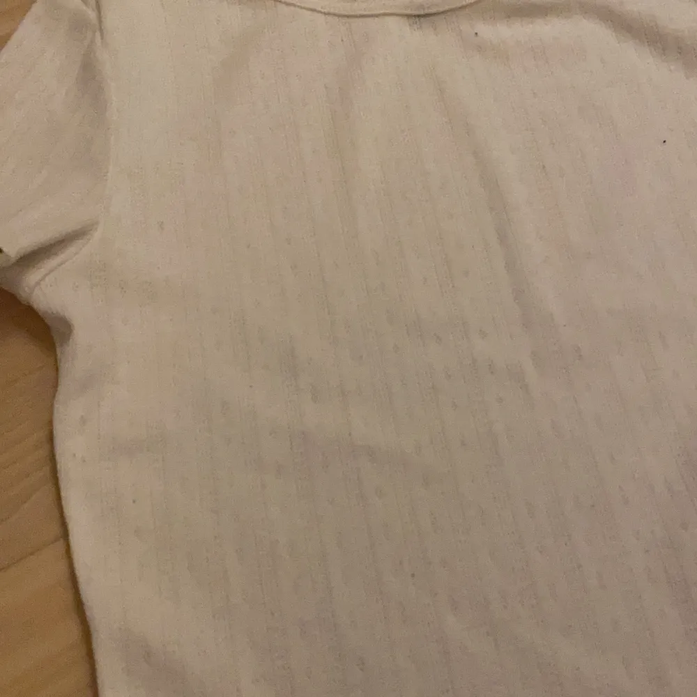 en vit lite tunnare t-shirt med hålbroderi. Väldigt bekväm och sitter bra på.. T-paidat.