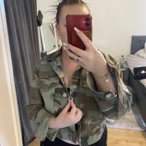 Jeans jacka  - En kortare Jeansjacka i militär mönster, knappar och små fickor. Storlek L passar även M