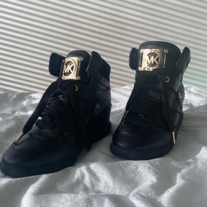 Michael kors sneakers  - Ett par fantastiska michael kors sneakers som är i fantastisk skick dem har svart som basfärg och rosegulda detaljer som verkligen ger skon en upplysning.