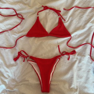 Bikini - Snygg röd bikini som aldrig är använd. Detalj med snöre kring magen. Storlek L men mer åt en S/M, säljer den för 50kr+ frakt!! 🤍