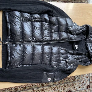 Moncler Cardigan - Säljer en Moncler cardigan i storlek L och svart färg. Jättebra kvalite och topp matrial. Den är i nyskick.  Har du några frågor eller funderingar är det bara att skriva till mig :)