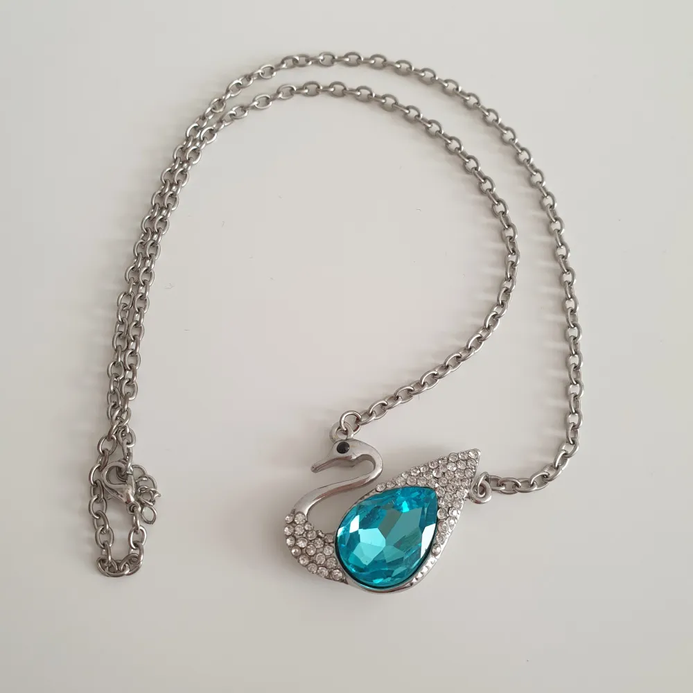 🦢FÖRST TILL KVARN🦢 Ett silvrigt halsband med ett svan hänge, täckt i en stor blå och flera små kristaller. (Osäker om det är zircon kristaller eller glas) har inte använt denna på länge, den förtjänar ett nytt älskande hem🩵 95+ frakt. Accessoarer.