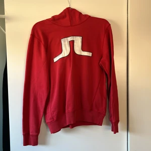 Hoodie J Lindeberg, Röd - Hoodie från J Lindeberg i storlek medium. Snöret saknas, men det är ju lätt att sätta dit ett nytt.