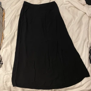Svart kjol - Svart kjol som går över knäna från Amisu. Storlek 34, är inte stretchig!