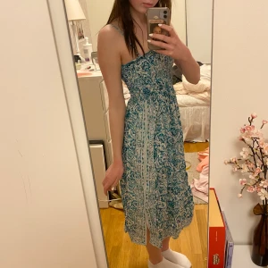 Sommarklänning  - Sommarklänning/strandklänning från Indiska! Jag är 162cm. Färgen är lite grönblå. Banden är justerbara och går att ta av!<3