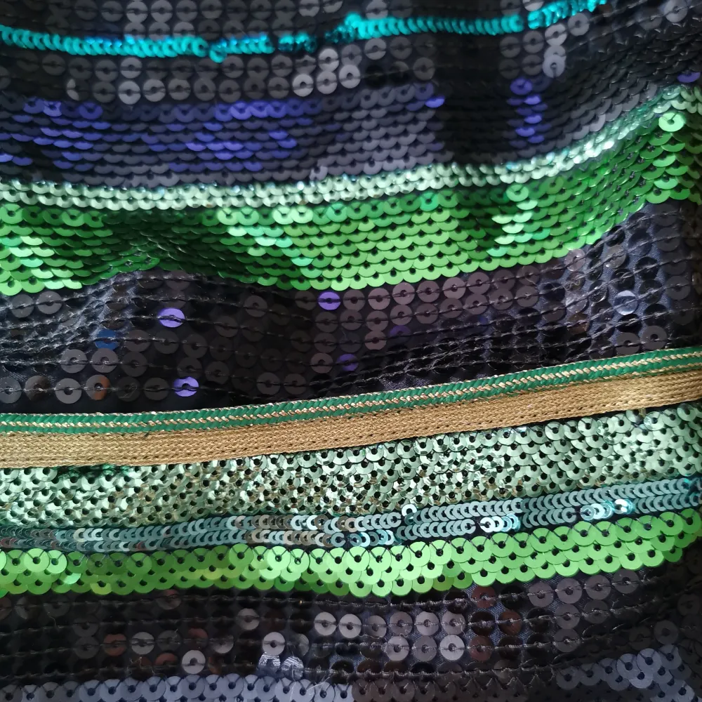 Kjol med paljetter i gröna nyanser Snygg och sitter åt men samtidigt bekväm på insidan med ett annat material (se foto) . Kjolar.