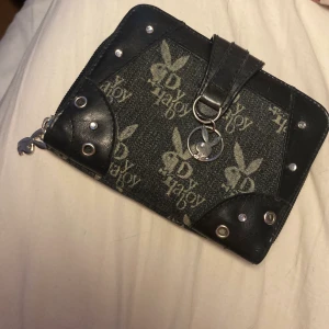 Playboy  - Playboy plånbok i jätte bra skick, det är bra material och knappt använd. Ena diamanten har ramlat av från en utav berlockernas ögon, men inget som är märkvärdigt. Detta är en intresse koll är inte helt säker på om jag vill sälja❤️ Skriv om ni undrar något