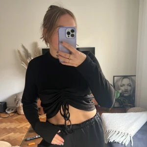 Svart topp  - En svart topp i ribbat tyg med scrunch och snörning! Går att dra upp som man vill. Strl L men passar mig som är en S/M! 🖤