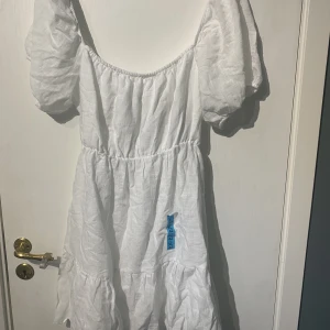 Pull&Bear vit klänning - En jättefin vit klänning som passar bra till sommaren eller studenten. Storlek xl/42 säljer då den inte passade mig. Helt oanvänd. Köparen står för frakt. 