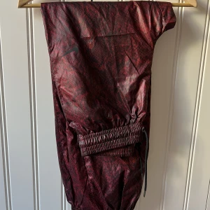 Nike byxor - Nike byxor i rött ormmönster. Aldrig använda. Storlek XS.  Köpare står för frakt.