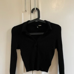 Svart topp - En crop topp, liknande piké från H&M med krage. Oanvänd och i fint skick. Storlek S