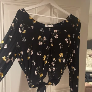Hollister blus - Blommig blus från Hollister med ett knyte i ryggen längst ner, storlek M. 60kr+frakt