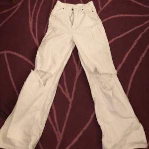 Vita jeans som är långa, utsvängda och bagge längst ner med slitage vid knäna. Väldigt tajta i midjan och lår. Orginal priset låg runt 700 oC ha byxorna är i nyskick.
