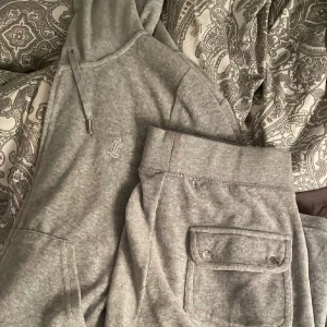 GRÅTT JUICY DRESS - Köpt för några månader sen, säljer pga dom inte passar mig längre. Både koftan och byxan är i storlek M. Tappade för någon månad sen foundation vid inre lår på byxan som har ändå lyckats komma bort som du ser på bild 2!! - köpt för 2300 säljer för 1200! 