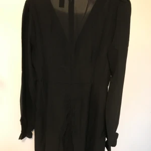 Fodrad v-ringad klänning - Oanvänd klänning som är fodrad, v-ringad med resår nertill på ärmarna, något klockad nertill, stl S. Frakt betalas av köparen.