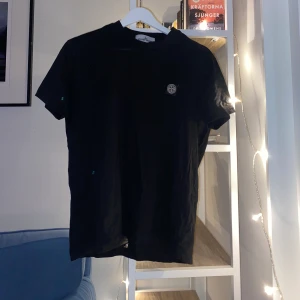 Stone Island T-shirt Svart - Svart Stone Island T-shirt som är i ett väldigt bra skick! Säljer eftersom den är lite för åtsittande på mig!! 
