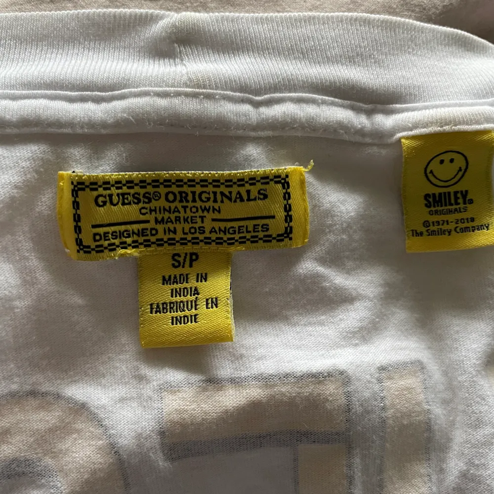 Snygg t-shirt med gult tryck från märket Guess köpt på själva Guess butiken i New York. Använd ett mycket fåtal gånger, därav i princip i nyskick. Passar även en M eller L pga oversized passform! . T-shirts.