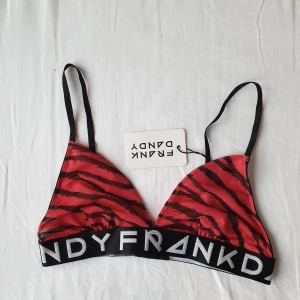 Oanvänd Frank Dandy bralette/bh - En asfin bralette från Frank Dandy i coolt svartrött tiger eller zebramönster (är lite osäker på vilket det är men coolt iaf haha). Säljer pga kommer inte till användning tyvärr. Oanvänd, lappen kvar. Mesh. Ordinarie pris 249:-