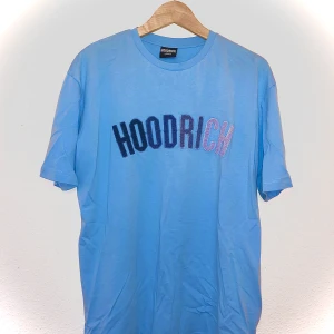 Hoodrich tracksuit - Oanvänd ljusblå Hoodrich tracksuit d.v.s t-shirt och shorts. Perfekt för sommaren.  Kunden står för kostnaden av frakt.