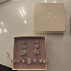 lily and rose armband & örhängen - matchande ser med örhängen samt armband. kommer aldrig riktigt till användning då jag föredrar guld :) jättefint set annars i väldigt bra skick!!
