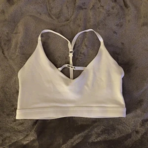 Nike sportbh - Säljer min vita Nike sport bh som aldrig är använd. Träningstopp💪🏼💪🏼🤍🤍