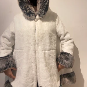 Vit kappa - Vit kappa med fake päls. Spänne av stenar. Varm men inte superduper varm. Inga fläckar eller hål. Väldigt skönt material. Uppskattas till large. Skriv vid funderingar! :p