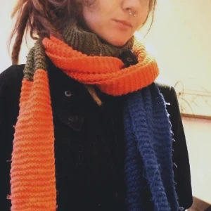 Multifärgad stickad halsduk - Stickad halsduk i blå, orange och mossgrön. 2,64 m lång och jättemysig. Var min favorithalsduk i flera år men nu behöver den ett nytt hem. 🥰