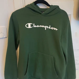 Champion Hoodie Grön - 10/10 skick då jag aldrig använt den.  Rekommenderar för storlek XS men den funkar även till S bara att den blir lite tajt. Säljer den billigt då jag vill rensa min garderob.