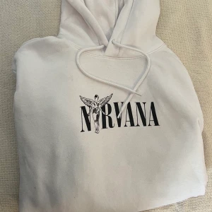 Vit Nirvana hoodie med Curt Cobain tryck✨ - Dmmysig hoodie med Nirvana loggan på framsidan och print på ryggen, säljer pga att jag ej använder den, bra skick utan fläckar/hål, perfekt som julklapp till både tjejer och killar(passar S). Köptes på H&M divided. 