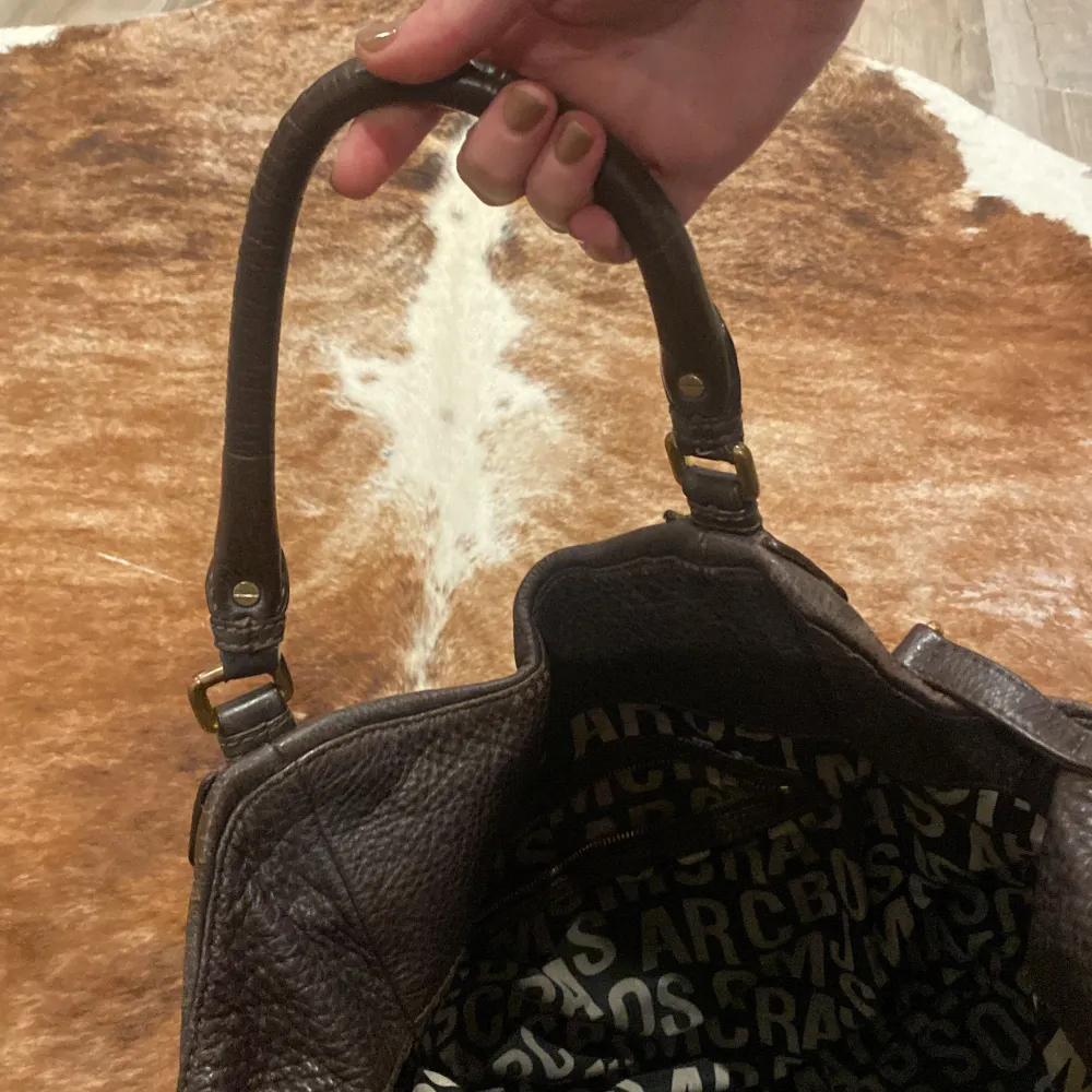 Snygg stor Marc Jacobs väska i mörkbrunt läder, inköpt på NK 2013. Lite slitningar i skinnet men på det stora hela i fint skick.. Accessoarer.