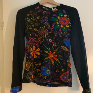 Multifärgad långärmad t-shirt med blommiga motiv - Super fin långärmad Multifärgad t-shirt i storlek S med en dragkedja. Ej stretchigt material. Aldrig använd och i bra skick!🖤