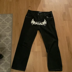 Y2k ”faces” jeans - Helt ny. Beställde L men det passade inte ändå. Verkligstorlek är S (baggy) eller M. Midja: 82 cm (omkrets) Längd: 97 cm  (Pris kan diskuteras)