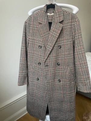 HELT NY Rutig kappa - Supersnygg kappa från Gina tricot, använd en gång vid ett fototillfälle. Rak modell/lite oversized. Storlek 34