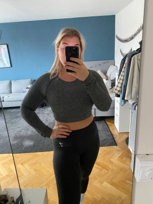 Grå träningstopp gymshark  - Grå croppad långärmad träningstopp från gymshark i grymt skick!