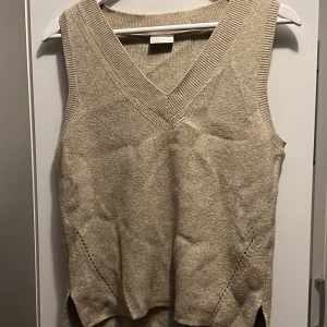 En stikad beigeväst med v-ringning - Säljer denna fina västen eftersom att jag inte använder denna längre, den är använd ca 2 gånger.