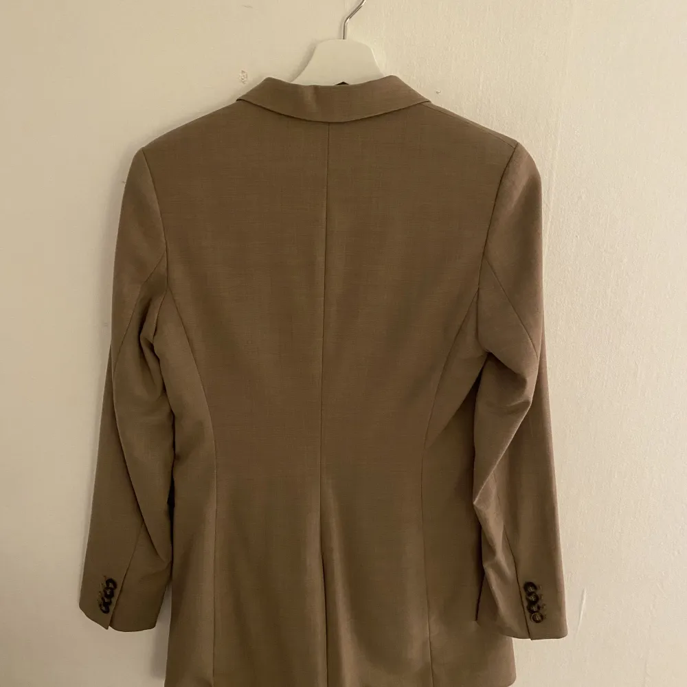 Beige kavaj från h&m. Helt oanvänd och ny. Köpte men den passa inte riktigt mig (lite lång i armarna på mig som är 160) men glömde att lämna tillbaka. ): så nu säljer jag den istället, nypris 499kr. Kostymer.