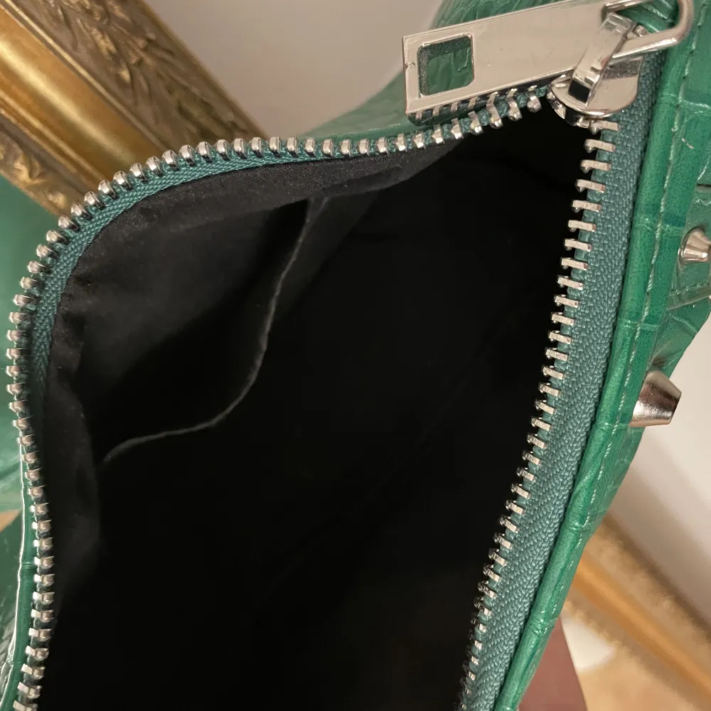 Säljer denna mörkgröna axelremsväskan med nitar på, den är i ett bra skick då den inte har användts så mycket😊 Går att göra bandet längre eller kortare.. Väskor.