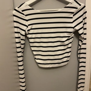 Långärmad topp - Svartvit randig långärmad topp med öppen rygg i super skönt material! Den är använd men i fint skick! 🤍🖤(Jag betalar inte frakten)