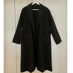 Kapoa - Svart lång oversized kappa. Kappan är lite tunnare så perfekt till våren eller med layering.  Kan mötas upp i Jönköping eller Vaggeryd annars tillkommer fraktkostnad 🤍