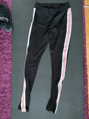 Gulliga tights - Svarta tights med vita och råsa stripse på sidan. Använda fåt antal gånget. Du betalar för shipping.