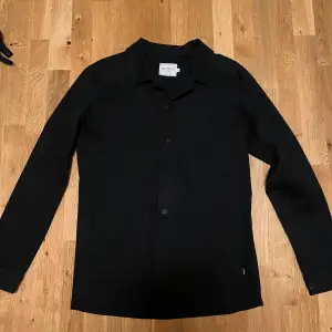 En svart overshirt i en skön stretch. Nypris 1400 kr