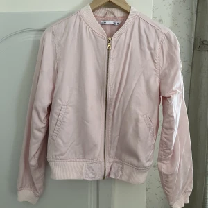 Bomberjacka  - Tunn ljusrosa bomberjacka från lager 157, färgen syns bättre i det andra fotot. Är i barnstorlek 160 men motsvarar ungefär XS.