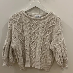 Stickad topp, NA-KD. Strl. S - Beige stickad topp/tröja med kortare ärmar från NA-KD Reborn. Storlek S/Small. Använd endast ett fåtal gånger.