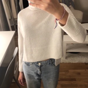 Stickad tröja med slits  - Vit stickad tröja med slits på sidan och hög krage från Gina tricot