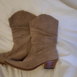 Mocka boots - Coola och trendiga mockaboots i storlek 41. Helt fantastiska till långa kjolar eller somriga festivaloutfits. Skorna är i bra skick och sparsamt använda. Tyget är rejält och har en mjukare "stoppning" inuti för komfort. 