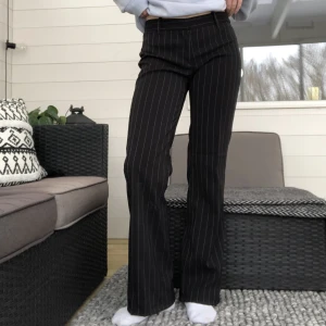 Randiga kostymbyxor - Super snygga svarta mid/low rise kostymbyxor med tunna vita ränder på💘midjemått är 75 cm och längd är ca 99 cm💘Har sytt upp byxorna och dom är nu perfekt långa för mig som är ca 162 cm! Innehåller 96% polyester och 4% elastan💙 säljer då dom ej används